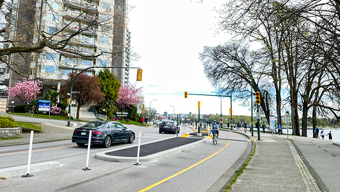 Cyclist riding down separate bike lane on Beach Ave with cars on the other side