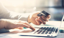 Man holding bank card while on laptop