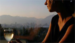 Woman drinking a glass of wine at Seasons in the Park restaurant with a view of the North Shore Mountains