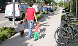Parent walking with 2 toddlers in the Creekside area